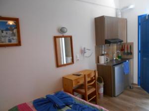 a room with a kitchen with a bed and a table at Studios Apartments Kapetanios in Perissa