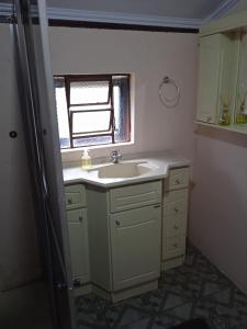 La salle de bains est pourvue d'un lavabo et d'une fenêtre. dans l'établissement Casa Refúgio e Aconchego, à Igrejinha
