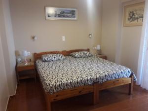 a bedroom with a wooden bed with two pillows on it at Nea Styra seafront apartment with stunning view in Nea Stira
