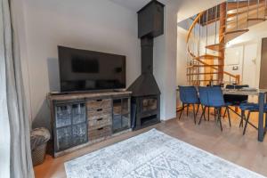 a living room with a television and a table with chairs at Casa Sanchines - Apartamentos Loira in Benasque