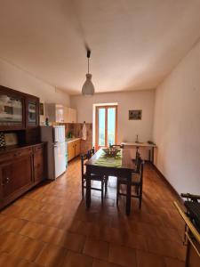 een keuken met een tafel en stoelen in een kamer bij Appartmento Rustico Montagna Val Maira Castellaro in Macra