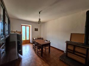 a living room with a table and a kitchen at Appartmento Rustico Montagna Val Maira Castellaro in Macra