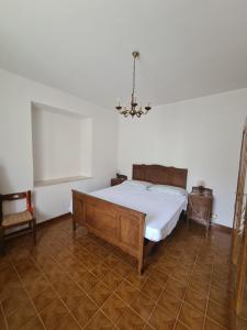 een slaapkamer met een bed en een kroonluchter bij Appartmento Rustico Montagna Val Maira Castellaro in Macra