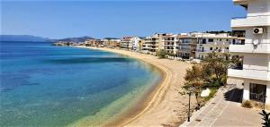 a view of a beach with buildings and the ocean at Nea Styra seafront apartment with stunning view in Nea Stira