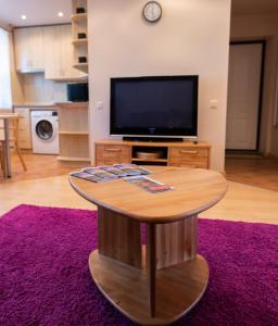 a living room with a coffee table and a tv at Apartament Amber, Liepāja in Liepāja