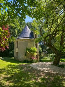 an old house with a tower in the grass at Château de Montaupin in Oizé