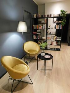 Duas cadeiras e uma mesa numa sala de estar em Piumaviola Beds & Apartments em Parma