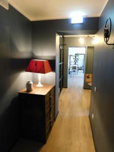 a room with a table with a lamp and a hallway at Piumaviola Beds & Apartments in Parma