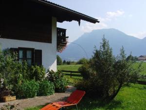 a red chair sitting in front of a house at Ferienwohnung Wechselberger in Kiefersfelden