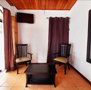 two chairs and a coffee table in a living room at Uruka Lodge in Alajuela