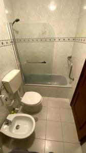 uma casa de banho com um WC e uma banheira em Half Way Nazaré - Fátima em Marrazes