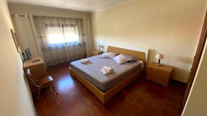 1 dormitorio con 1 cama con 2 toallas en Half Way Nazaré - Fátima, en Marrazes