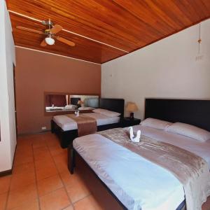 1 dormitorio con 2 camas y ventilador de techo en Uruka Lodge en Alajuela