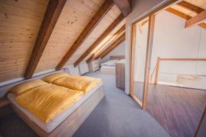 a bedroom with two beds in a room with wooden ceilings at ZORE JASNÁ Apartments in Belá