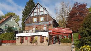 ein großes Haus mit einem Gamer-Dach auf einer Straße in der Unterkunft Paul Lincke Residenz in Hahnenklee-Bockswiese