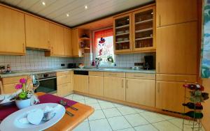 a large kitchen with wooden cabinets and a table at FreiRaum in Obersinn