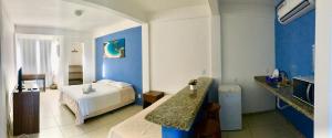 a bedroom with a bed and a sink in it at Caiçara Flats in Cabo Frio