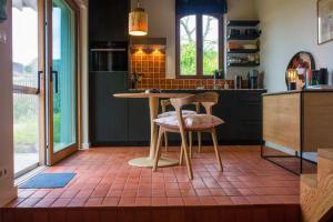 Maisonnette FREA في Rozebeke: مطبخ مع طاولة و كرسيين