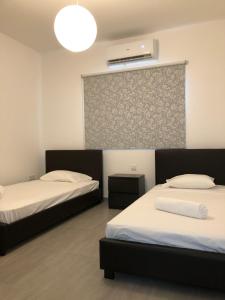 Habitación con 2 camas y pared en Katalimata Court en Ayia Napa