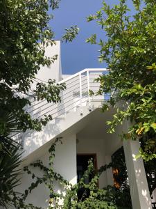 Casa blanca con balcón y árboles en Katalimata Court en Ayia Napa