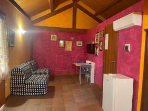 una stanza con pareti rosa, una sedia e un tavolo di Chalet monolocale a Vieste Altre 27 foto