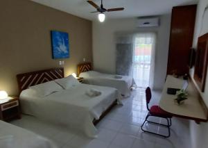 Hotel Costa Azul في كانانيا: غرفة فندقية بسريرين وكرسي