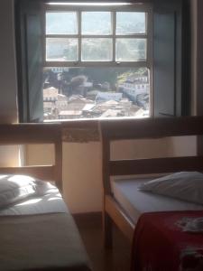 a bedroom with a window with a view of a city at Pousada Tiradentes in Ouro Preto