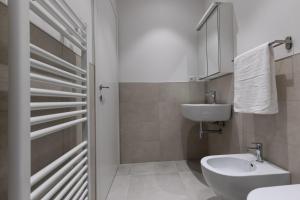 a white bathroom with a sink and a toilet at Verona Suites in Verona