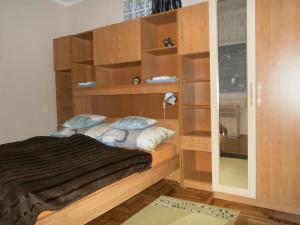 een kleine slaapkamer met een bed met houten planken bij Csikász Vendégház in Nagyvisnyó