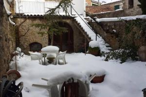 un patio cubierto de nieve con mesa y sillas en Cal Marquès en Cerviá