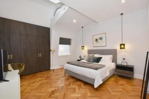 a bedroom with a bed and a desk and a television at London Choice Apartments - Mayfair - Piccadilly in London