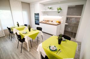 une salle à manger avec deux tables avec des nappes jaunes dans l'établissement B&B Il Soffione, à Fonzaso