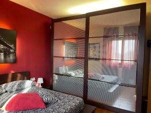 a bedroom with red walls and a bed with a large glass closet at Le Case di Cinzia in Vinci