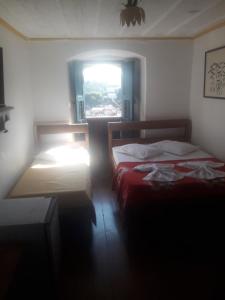 two beds in a room with a window at Pousada Tiradentes in Ouro Preto