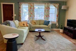 sala de estar con sofá y TV en Peaceful Garden Oasis - 3 miles to downtown!, en Asheville