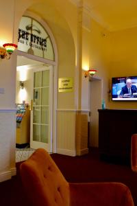 a waiting room with a door and a tv at The Station Aparthotel in Dudley