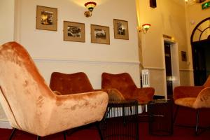a waiting room with orange chairs and pictures on the wall at The Station Aparthotel in Dudley