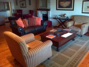 a living room with couches and a coffee table at Nautilus Guest House in Hermanus