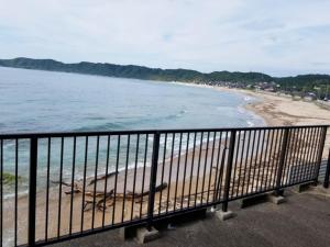 a view of a beach from a balcony at Uminomanmaesou - Vacation STAY 65243v in Oda