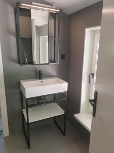 a bathroom with a white sink and a mirror at WALDVILLA Bad Kleinkirchheim in Bad Kleinkirchheim