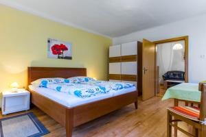 a bedroom with a large bed and a table at Ferienwohnung Helga Bergkirchner in Schwallenbach