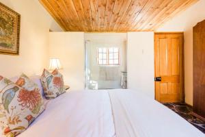 una camera da letto con un letto grande con soffitto in legno di Onbedacht Cottage a Graaff-Reinet