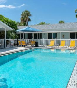 a swimming pool with blue water in front of a house at Park Shore Suites St Pete Beach in St. Pete Beach