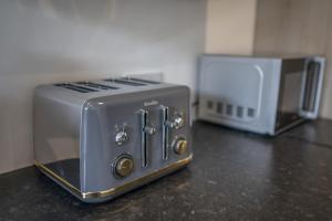 two toasters sitting on a counter next to a microwave at Waterfront luxury apartment in Kinghorn