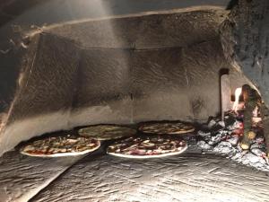 three pizzas are being cooked in an oven at Albergo Ristorante Monte Selva in Barisciano