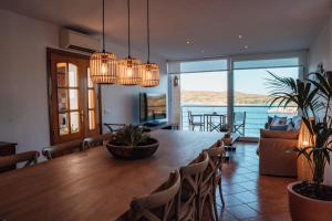 a dining room with a large wooden table and chairs at Menurka - Port d'Addaia in Port d'Addaia