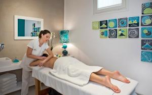 a woman sitting on a patient in a hospital bed at Hotel Della Piccola Marina in Capri
