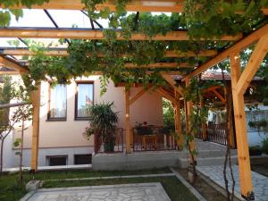 a wooden pergola with plants on it in a yard at Apartmani Jelica FREE PARKING in Vranje