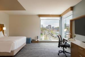 a hotel room with a bed and a desk and a window at EVEN Hotels Rochester - Mayo Clinic Area, an IHG Hotel in Rochester