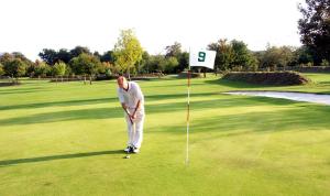 a man standing on a golf course with a number sign at L'Orangerie de Lanniron - Mobil-Home O'HARA privilège - 3 chambres - 6 pers in Quimper
